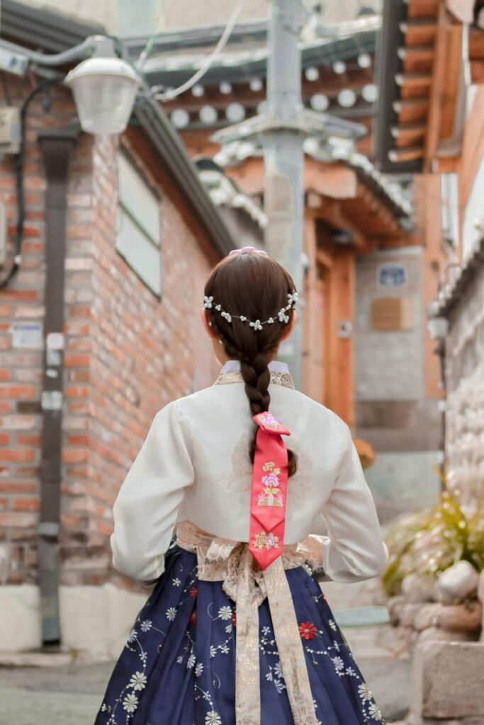 Capture of a woman in a hanbok walking through a traditional street in Seoul.
